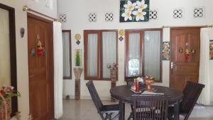 a dining room with a table and chairs and a door at Made Roejas Family in Uluwatu