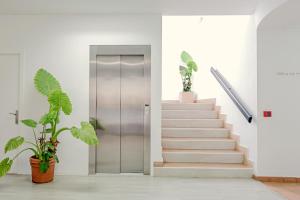 a hallway with stairs and a silver elevator at Lantana Garden in Pilas