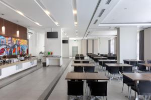 un restaurant avec des tables et des chaises dans une cafétéria dans l'établissement Amaris Hotel Slipi, à Jakarta