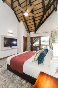 a bedroom with a large bed and a tv at Kruger Park Lodge Unit No. 608A in Hazyview
