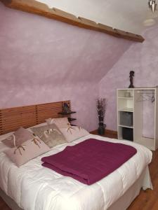 Renaissance في Nohant-en-Graçay: غرفة نوم مع سرير كبير مع ملاءات أرجوانية