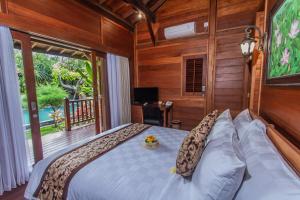 a bedroom with a bed and a large window at Batu Agung Villa Ubud in Ubud +52 photos