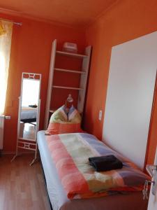 ein Schlafzimmer mit einer orangefarbenen Wand und einem Etagenbett in der Unterkunft Gästezimmer Fuchs in Neuhausen auf den Fildern