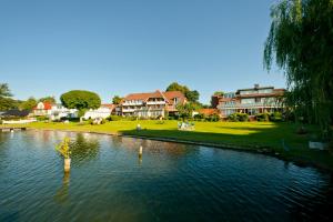 Blick auf einen See mit Häusern im Hintergrund in der Unterkunft Strauers Hotel am See in Bosau