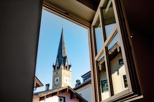 a view of a church steeple from a window at Roomie Alps Design Hostel in Kitzbühel