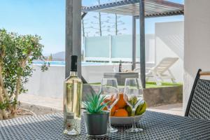 a bottle of wine and two glasses on a table at Casa amanecer 1 in Mácher