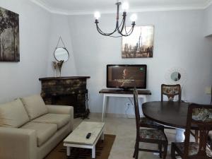 uma sala de estar com um sofá e uma mesa com uma televisão em El chalecito de Marta (PH) em Necochea
