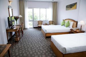 a hotel room with two beds and a television at Liberty Hotel Saigon Parkview in Ho Chi Minh City
