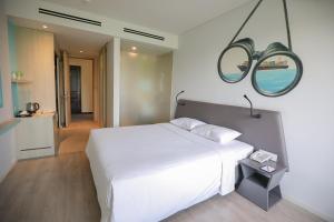 a bedroom with a white bed and a mirror at Liberty Hotel Saigon Parkview in Ho Chi Minh City