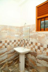 une salle de bains avec un lavabo et un miroir dans l'établissement Global Lake Villa Hikkaduwa, à Hikkaduwa