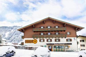 ein großes Gebäude mit Schnee davor in der Unterkunft Hotel Sonne in Wagrain