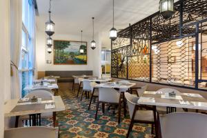 ジョグジャカルタにあるKHAS Tugu Hotel Yogyakartaのテーブルと椅子が備わるレストラン