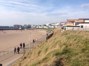 un gruppo di persone che camminano sulla spiaggia di Beulah Guest House a Portrush