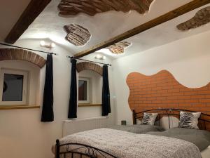 亚希莫夫Apartmany Pod Kloboukem的一间卧室，有两张床和一堵砖墙