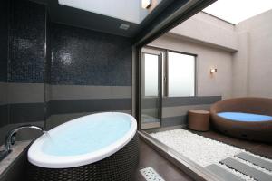 ein Badezimmer mit einer Badewanne, einem WC und einem Waschbecken in der Unterkunft HOTEL W-PREMIUM -W GROUP HOTELS and RESORTS- in Koshigaya