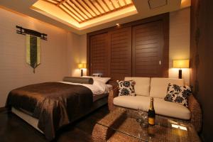 una camera con letto, divano e tavolo di HOTEL W-PREMIUM -W GROUP HOTELS and RESORTS- a Koshigaya