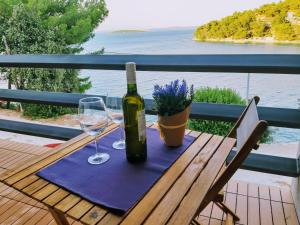 a table with a bottle of wine and two glasses at Apartman Bella 1 in Sali