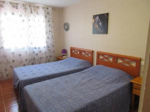 1 Schlafzimmer mit 2 Betten und einem Fenster mit einer Uhr in der Unterkunft Villa Duplex 8 Persons, Terrace, Swimming Pool And Bbq in Torrevieja