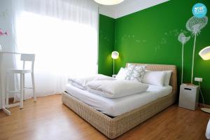 ein Schlafzimmer mit einer grünen Wand und einem Bett in der Unterkunft Stop & Sleep Udine Fronte Ospedale Civile in Udine