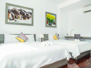 2 camas en una habitación con sábanas blancas en Ylang Garden Villa, en Hoi An
