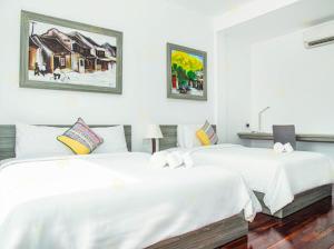two beds in a room with white sheets at Ylang Garden Villa in Hoi An +68 photos