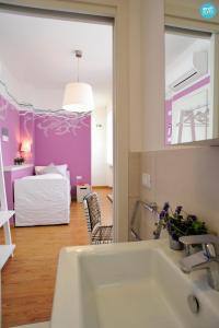 ein Bad mit einem Waschbecken und ein Zimmer mit einem Bett in der Unterkunft Stop & Sleep Udine Fronte Ospedale Civile in Udine