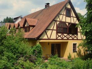 ein gelbes Haus mit braunem Dach in der Unterkunft Ferienhof Hohe in Hiltpoltstein