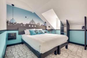 a blue and white bedroom with a large bed at Hôtel Lucien & Marinette in Paris