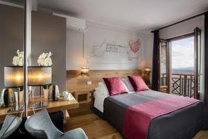 a bedroom with a bed and a desk and a window at Hotel La Cisterna in San Gimignano