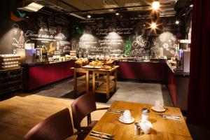a restaurant with two wooden tables and a bar at pentahotel Wiesbaden in Wiesbaden
