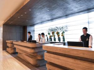 a group of people standing at a reception desk at Oasis Aurum 181 Hotel in Hong Kong
