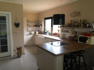 a kitchen with white cabinets and a counter top at Lakehouse Nakielno in Wałcz +14 photos
