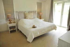 un dormitorio blanco con una cama con sombrero en Létan Lontan en Rodrigues Island