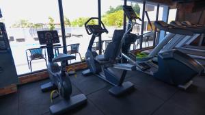 a gym with three tread machines and a window at Beverly Hotel Batam in Nagoya