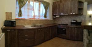 a kitchen with wooden cabinets and a sink and a stove at Vila Vladimir in Poiana Brasov