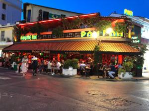 a group of people sitting outside of a restaurant at Appartement 3 pieces, refait a neuf, haut standing, piscine, mer a pieds in Antibes