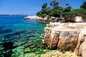 a rocky shore with clear blue water and rocks at Appartement 3 pieces, refait a neuf, haut standing, piscine, mer a pieds in Antibes
