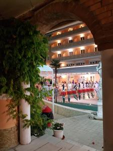 vista su un edificio con persone che ballano in piscina di Grand Hotel Osman & Spa e Ristorante il Danubio a Atena Lucana