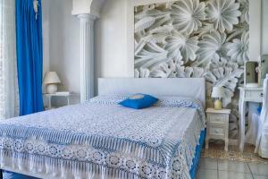 a bedroom with a bed with a blue pillow on it at B&B Il Bacio di Capri in Anacapri