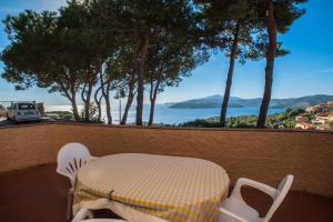 カポリーヴェリにあるVilla Rosannaのテーブルと椅子、水辺の景色を望むバルコニー