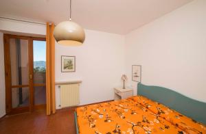a bedroom with a bed with an orange blanket at Villa Rosanna in Capoliveri