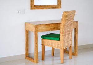 a wooden table and chair with a green seat at d'Sawah Amed Homestay & Warung in Amed