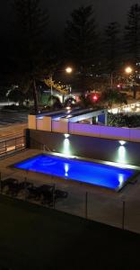uma piscina com luzes azuis à noite em Kirra Waves em Gold Coast