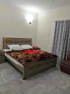 a bedroom with a bed and a chair at Star Hotel Lahore in Lahore
