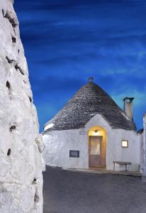 an outside view of a building with a thatch roof at Trulli Holiday Albergo Diffuso in Alberobello