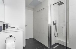 a white bathroom with a shower and a sink at Frish & Diz by HolyGuest in Tel Aviv