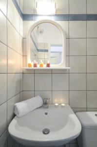 La salle de bains est pourvue d'un lavabo blanc et d'un miroir. dans l'établissement Bernie House, à Mélanes