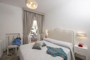 a white bedroom with a bed with a pillow on it at Palazzo Gargano Amalfi in Amalfi