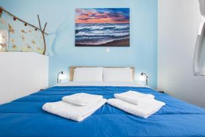 Una cama azul con dos toallas blancas. en Captain Elias Studios 1 en Kárpatos