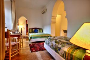 1 dormitorio con 2 camas, mesa y escritorio en Riad Aventurine, en Marrakech